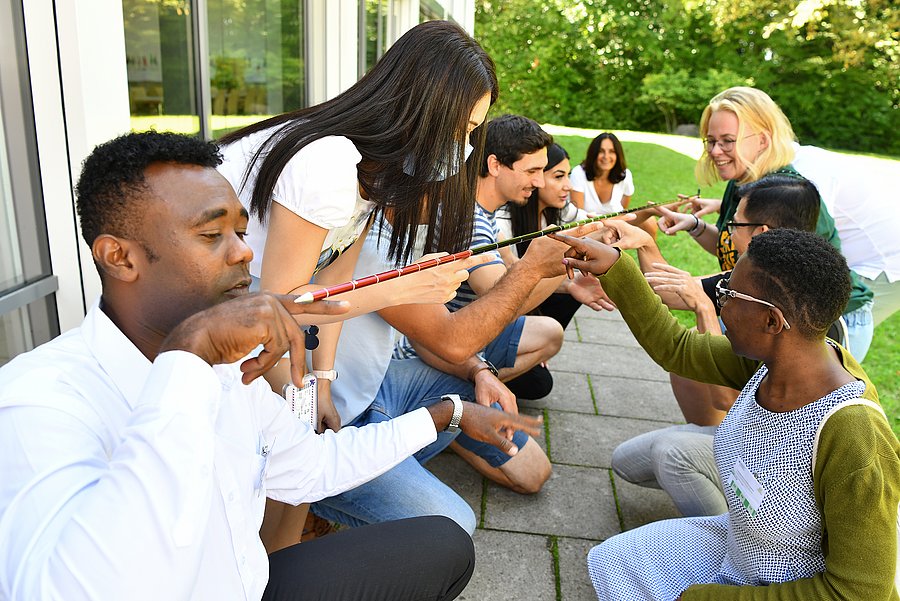 Seminarteilnehmer:innen bei Gruppenarbeit im Garten
